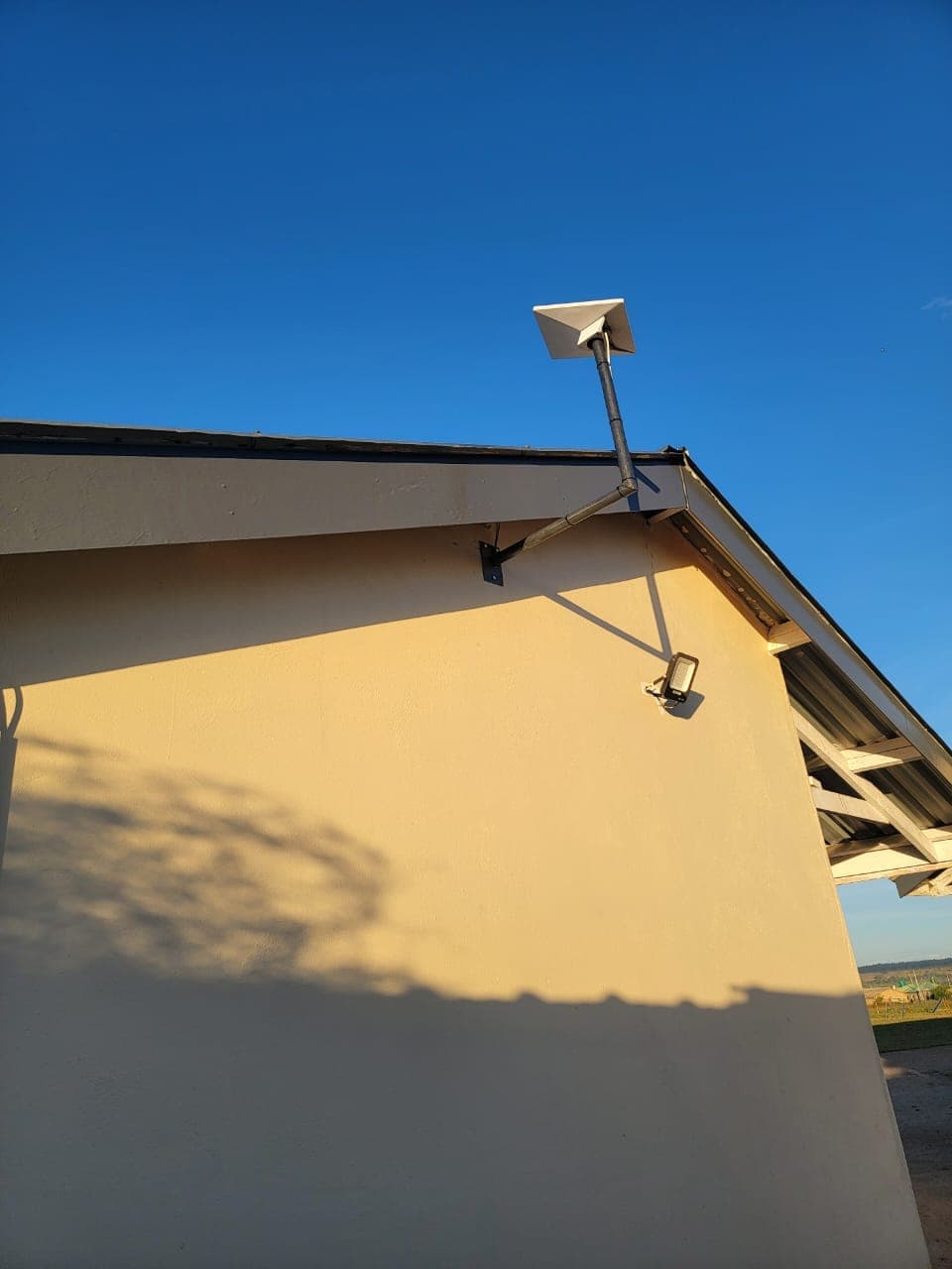Starlink dish wall-bracket installation on building exterior